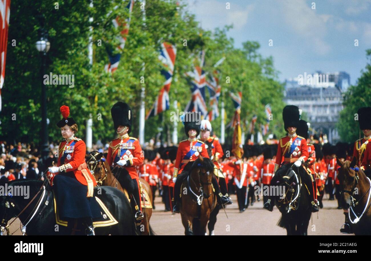 HM la Regina, seguita dal principe Filippo, che guida il Trooping il colore giù il centro commerciale sul suo cavallo birmano. Londra. REGNO UNITO. Circa anni 80 Foto Stock