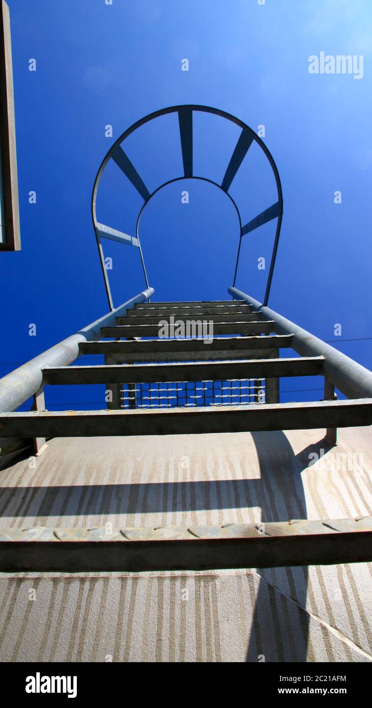 Vista dal basso di una scala con la barra di sicurezza. Il look simboleggia la salita con certezza. Foto Stock