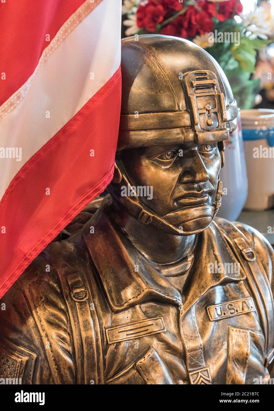 Statua all'aperto e bandiera di un soldato militare statunitense costruito in pietra di fusione con finitura in bronzo per la vendita presso un ristorante e negozio Cracker Barrel. Foto Stock