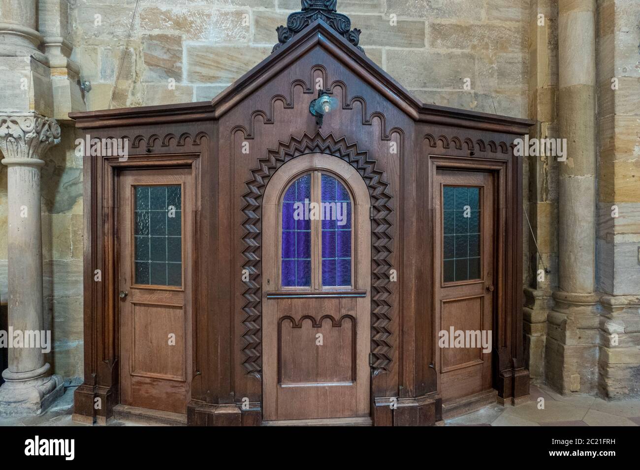 vecchia sedia confessionale di legno vuota in una chiesa Foto Stock