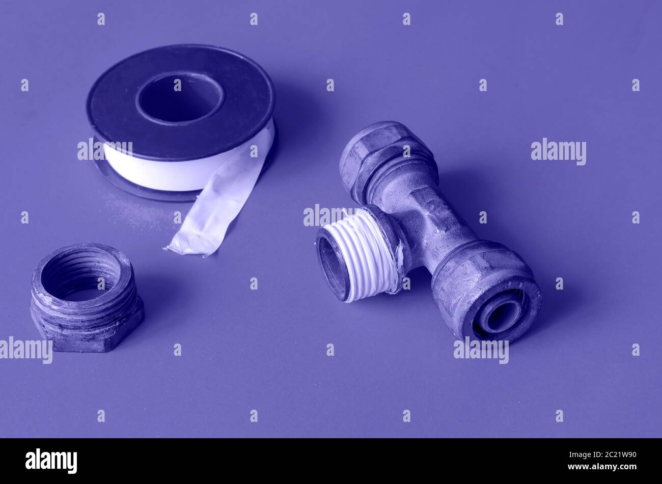 Separatore a T per acqua, dado e nastro sigillante. Il processo di riparazione dell'alimentazione idrica. Servizio idraulico. Primo piano. Messa a fuoco selettiva. ph oscurata Foto Stock