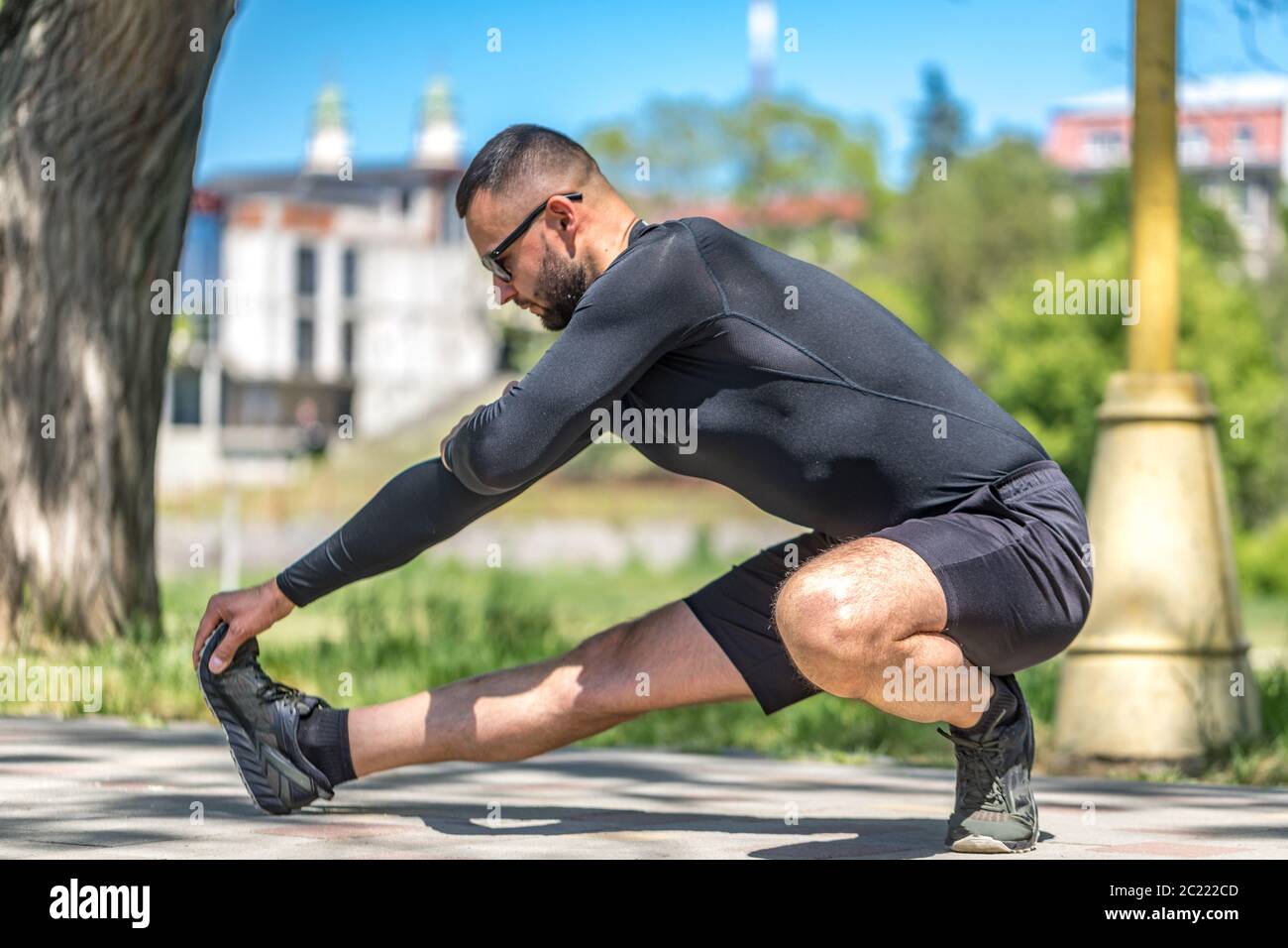 L'uomo si sta striando all'aperto in uno scenario cittadino, rappresentando un modello di stile di vita sano e attivo. Foto Stock