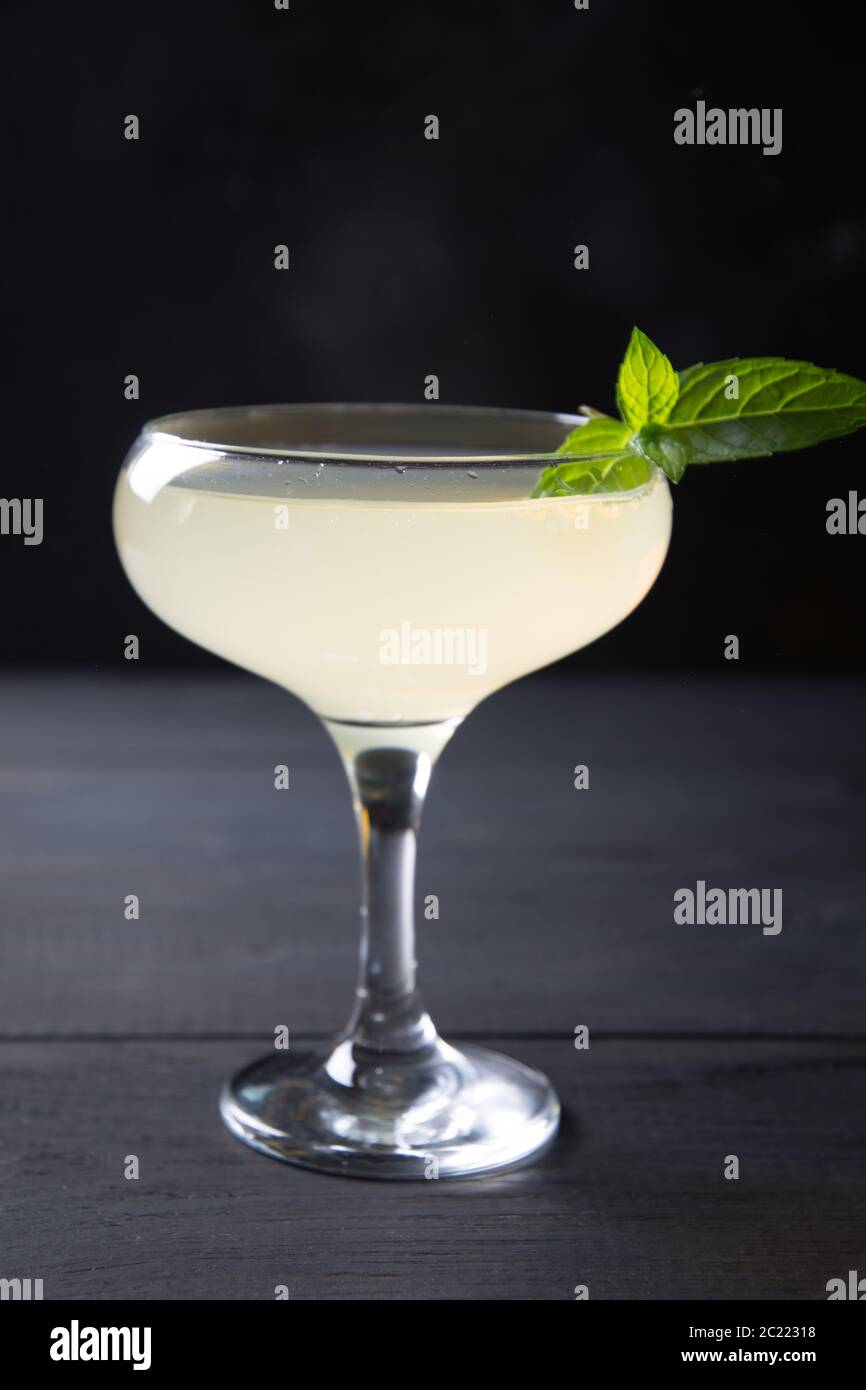 Freschezza e cocktail di agrumi in bicchiere di vino isolato al buio. Foto Stock
