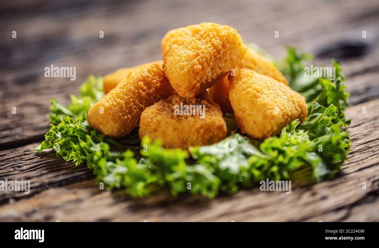Pepite di formaggio sulla parte superiore di foglia di insalata messo su un legno rustico Foto Stock