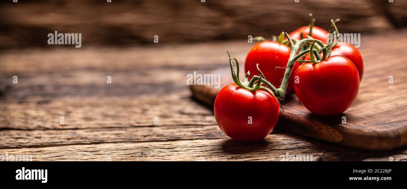 Mazzetto di pomodori freschi su una superficie rustica di legno Foto Stock