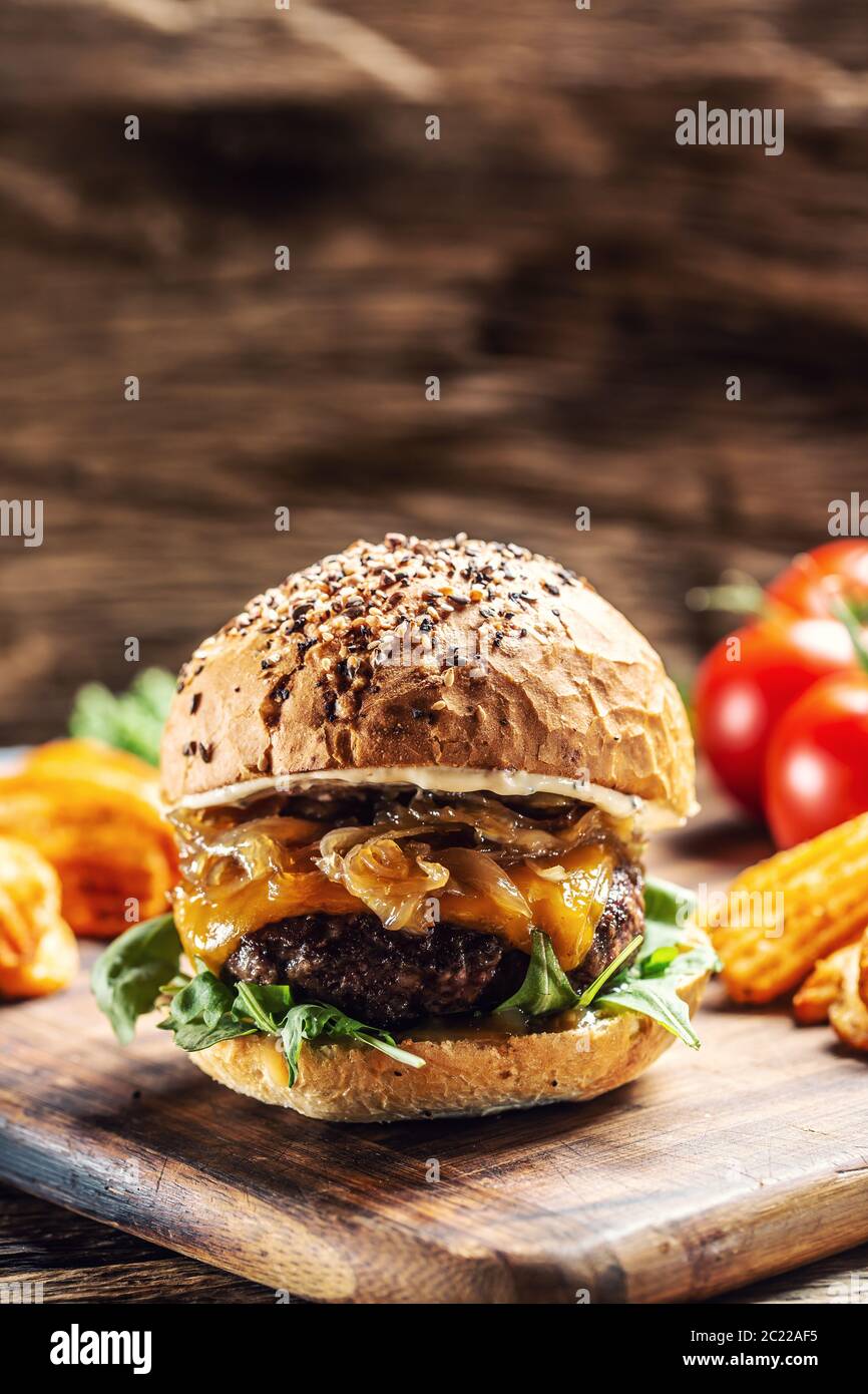 Hamburger di manzo con cipolla caramellata, rucola e formaggio fuso Foto Stock