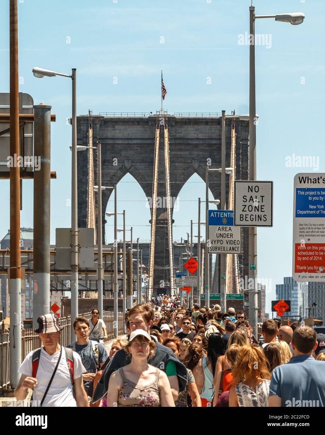 Molti turisti che attraversano il ponte di Brooklyn presso la testa di ponte di Manhattan Foto Stock