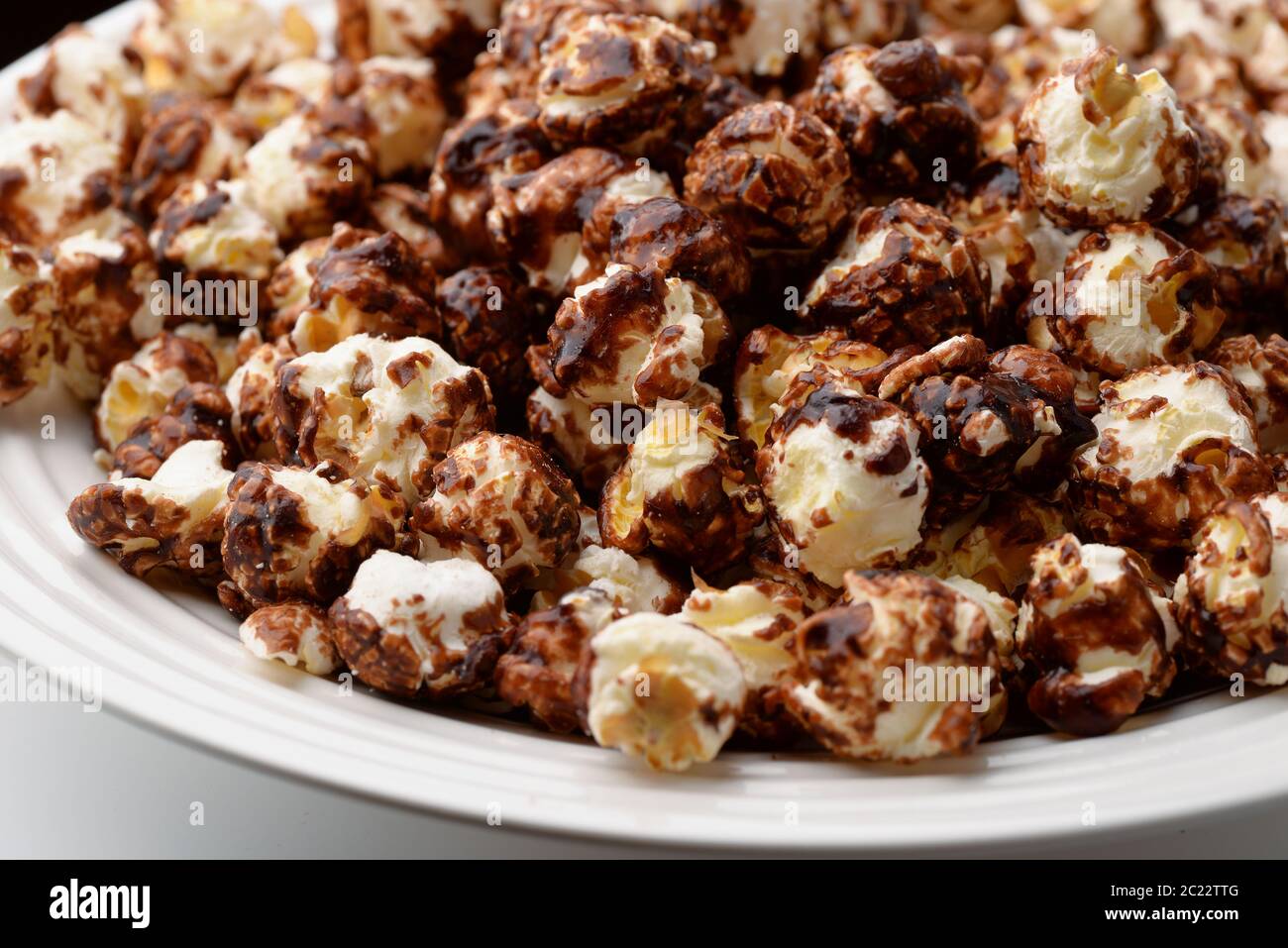 Primo piano di popcorn al cioccolato su piatto bianco Foto Stock