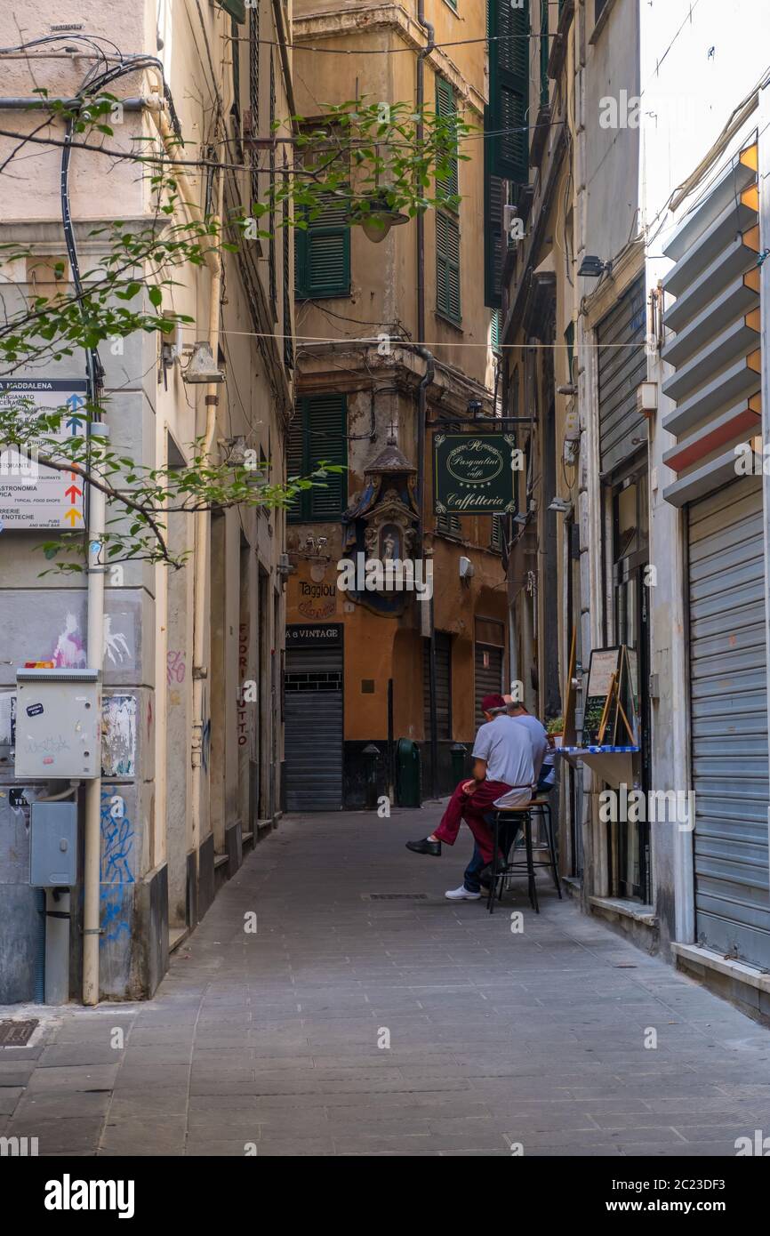 Genova - 20 agosto 2019: Tipica stradina di Genova con i caffè, i negozi e le facciate multicolore degli edifici, Liguria Foto Stock