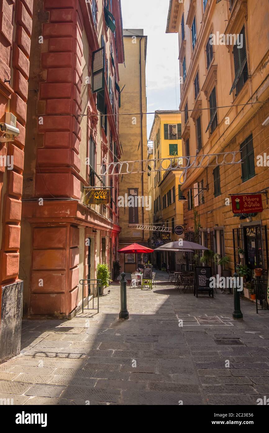 Genova - 20 agosto 2019: Tipica stradina di Genova con i caffè, i negozi e le facciate multicolore degli edifici, Liguria Foto Stock