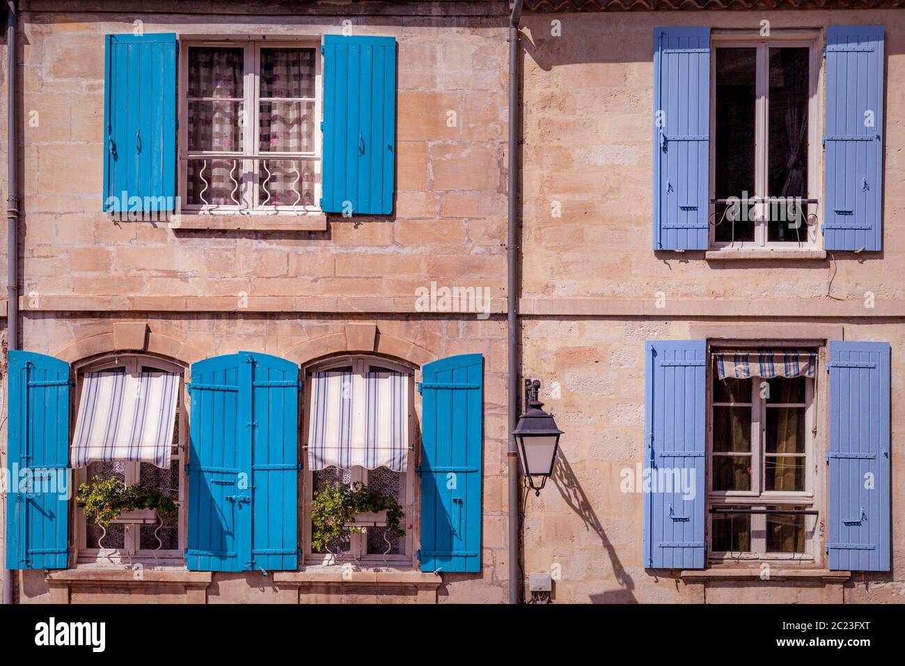 Persiane blu lungo il muro di casa nella città vecchia di Arles, Provenza, Francia Foto Stock
