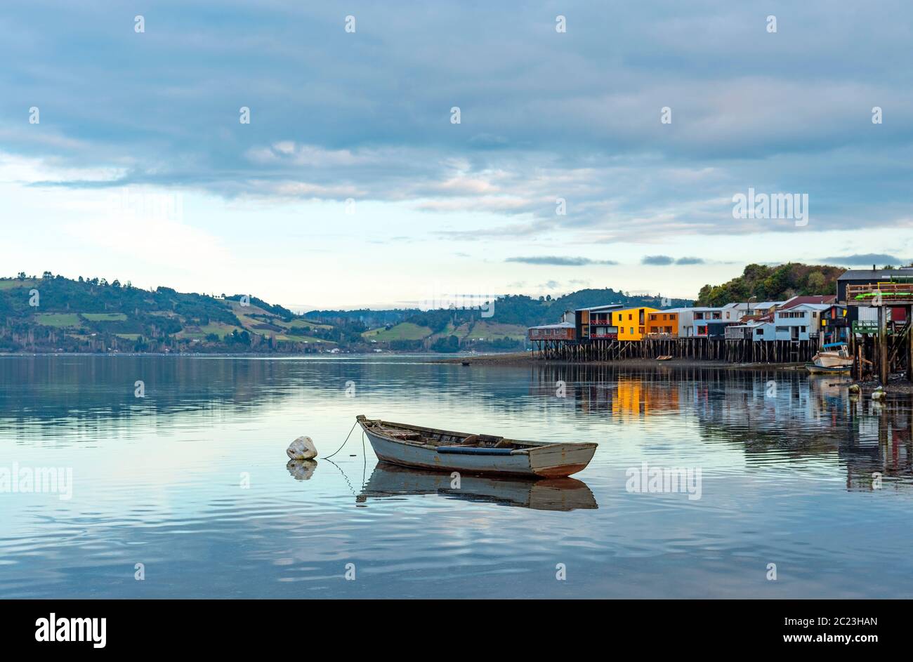 Una barca da pesca solitario presso le palafitos palafitte case a Castro, Isola di Chiloe, Cile. Foto Stock