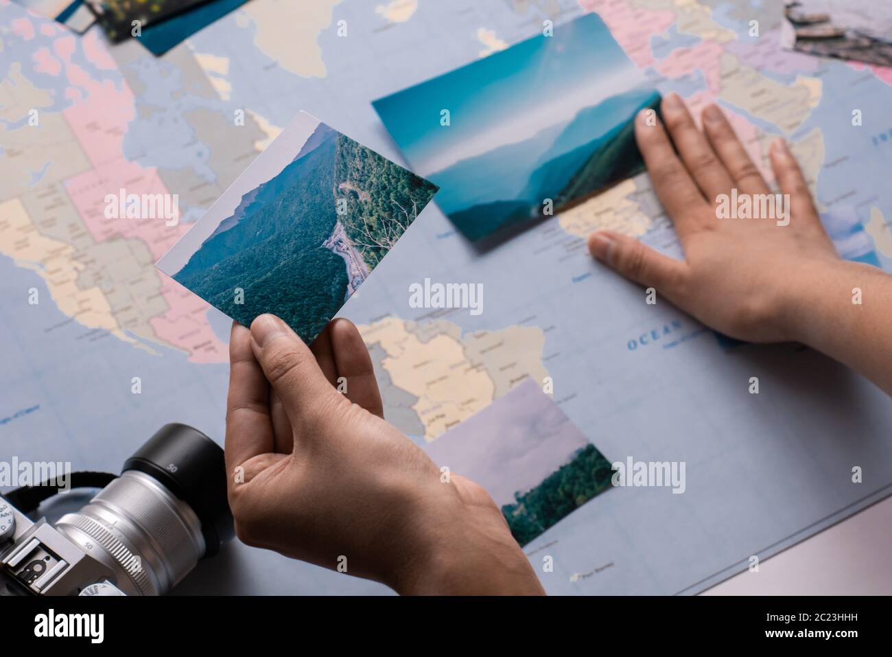 Primo piano di turisti irriconoscibili guardando le fotografie di viaggio e metterlo su carta mappa Foto Stock