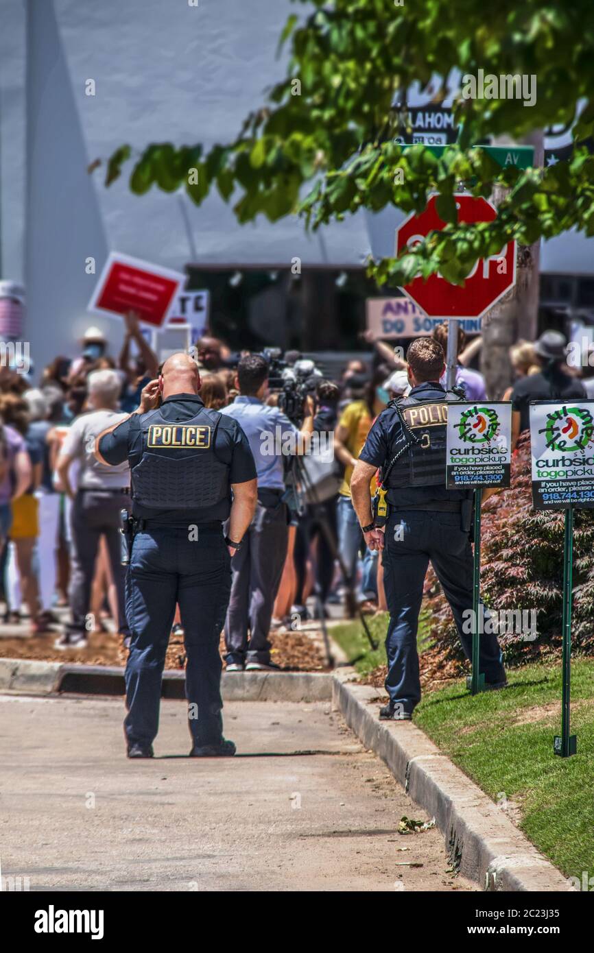 05-30-2020 Tulsa OK - due poliziotti e un cameraman fuori da una folla per le strade durante un rally BLM Foto Stock