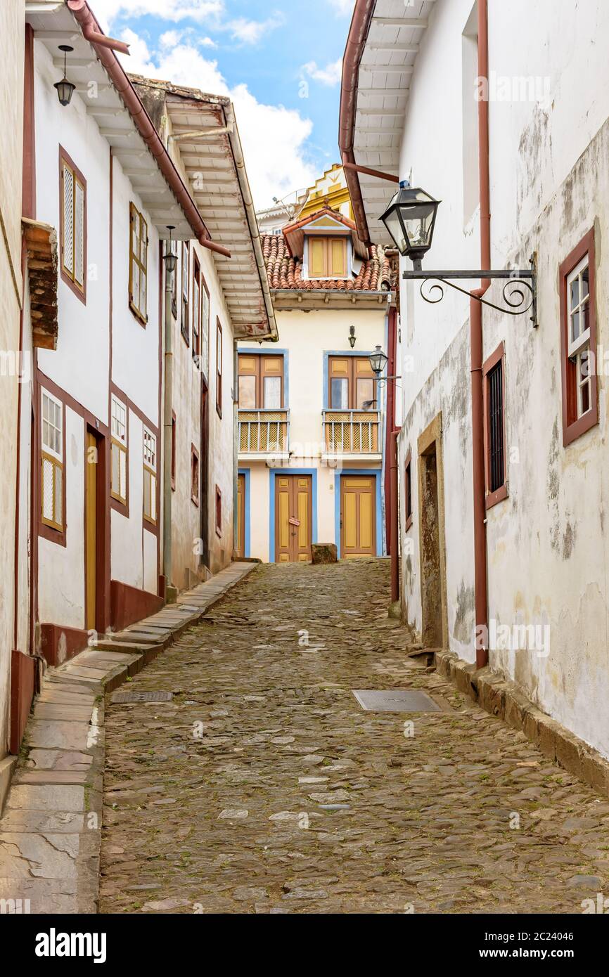 Facciata di vecchie case costruite in architettura coloniale e strada acciottolata Foto Stock Facciata di vecchie case costruite in architettura coloniale e strada acciottolata Foto Stock