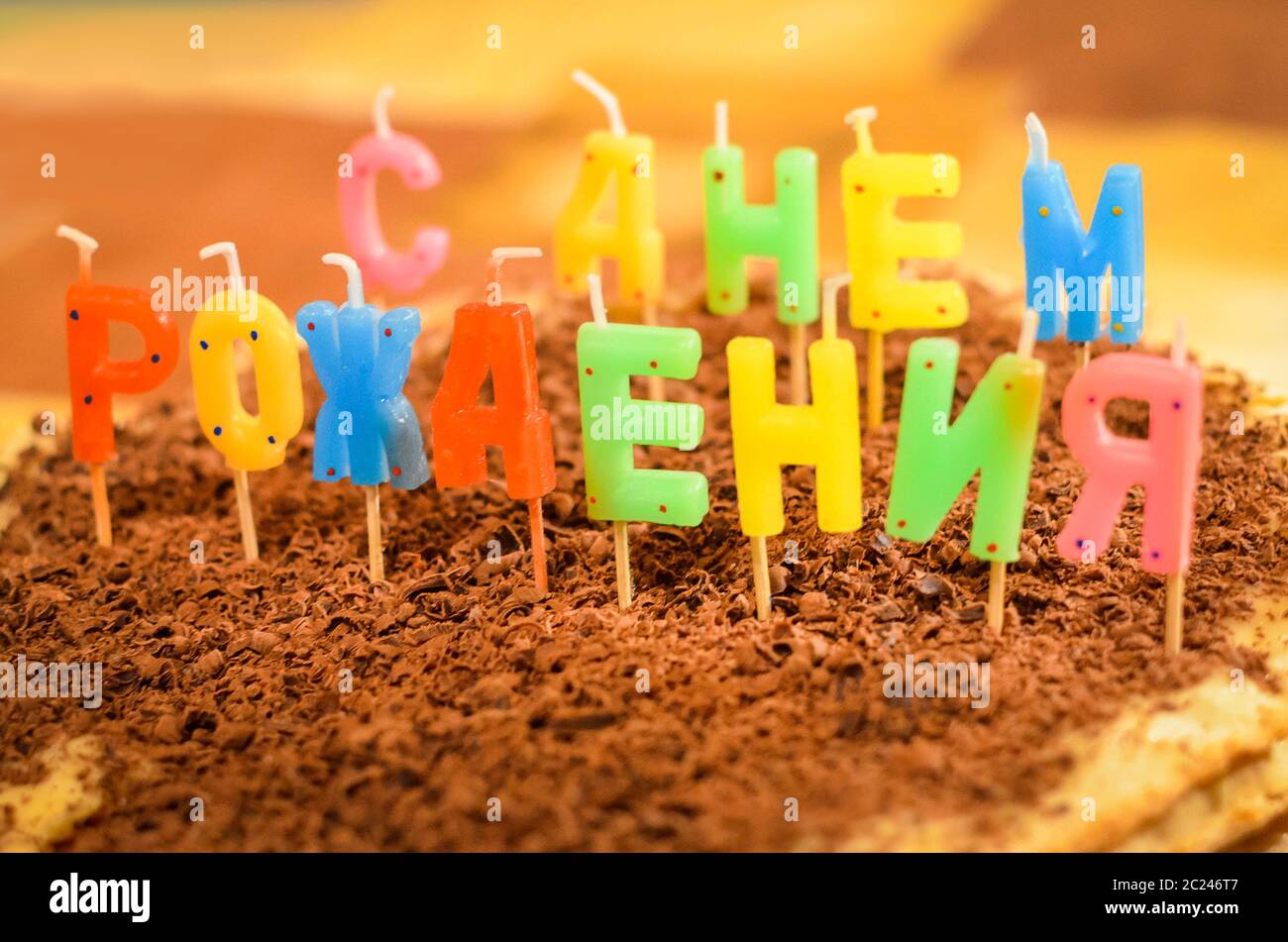 Torta di compleanno felice con candele in forma di lettere russe Foto Stock