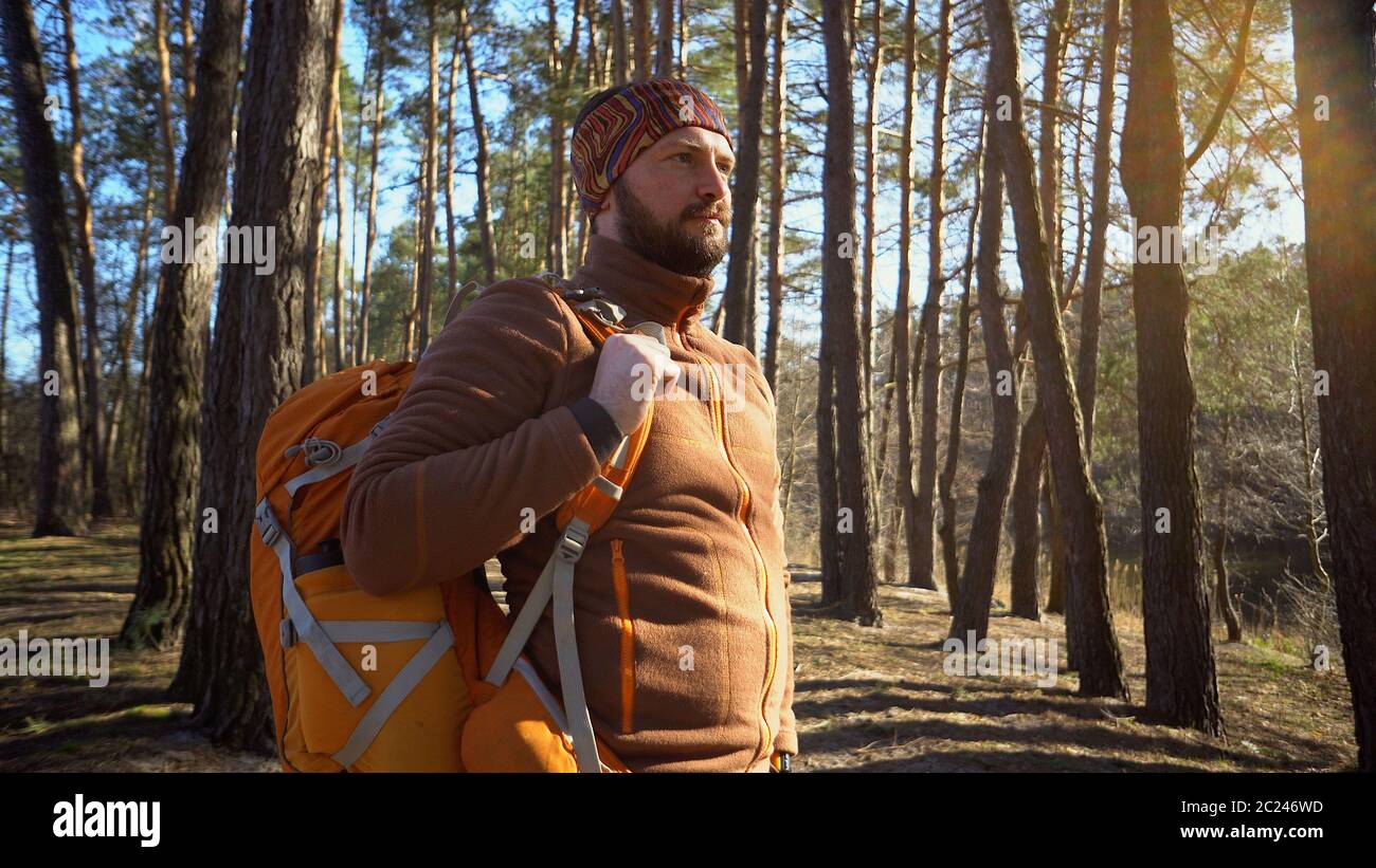 Active maschile sportivo ragazzo ritratto escursioni all'aperto. Giovane turista maschile con barba e bendaggio, fazzoletto sulla testa con un bac Foto Stock