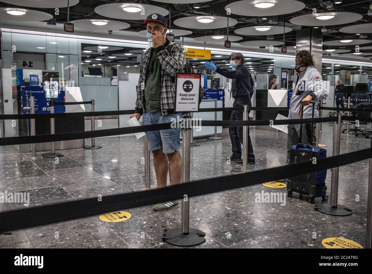 I viaggiatori che arrivano al Terminal 5 di Heathrow durante la quarantena di 41 giorni per cercare di controllare la pandemia del Coronavirus Covid 19 da parte dei passeggeri. Foto Stock
