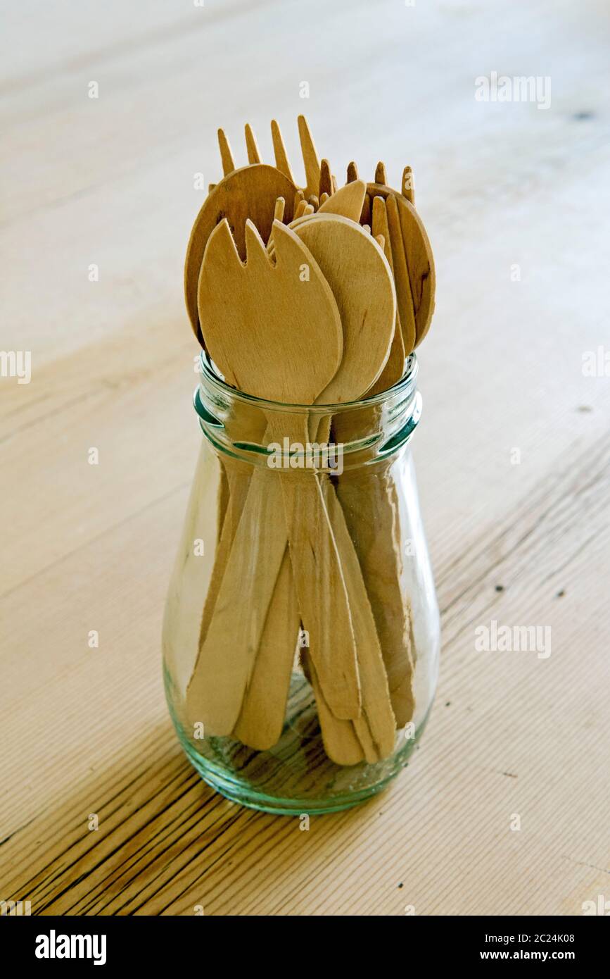 Posate in legno riciclate in vasetto di vetro riutilizzato su tavolo da cucina. Concetto di zero sprechi Foto Stock