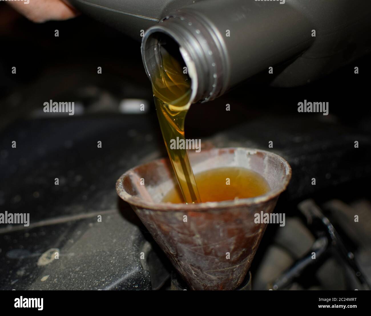 Cambio dell'olio nel motore dell'auto. Il riempimento dell'olio attraverso l'imbuto. Auto stazione di manutenzione Foto Stock