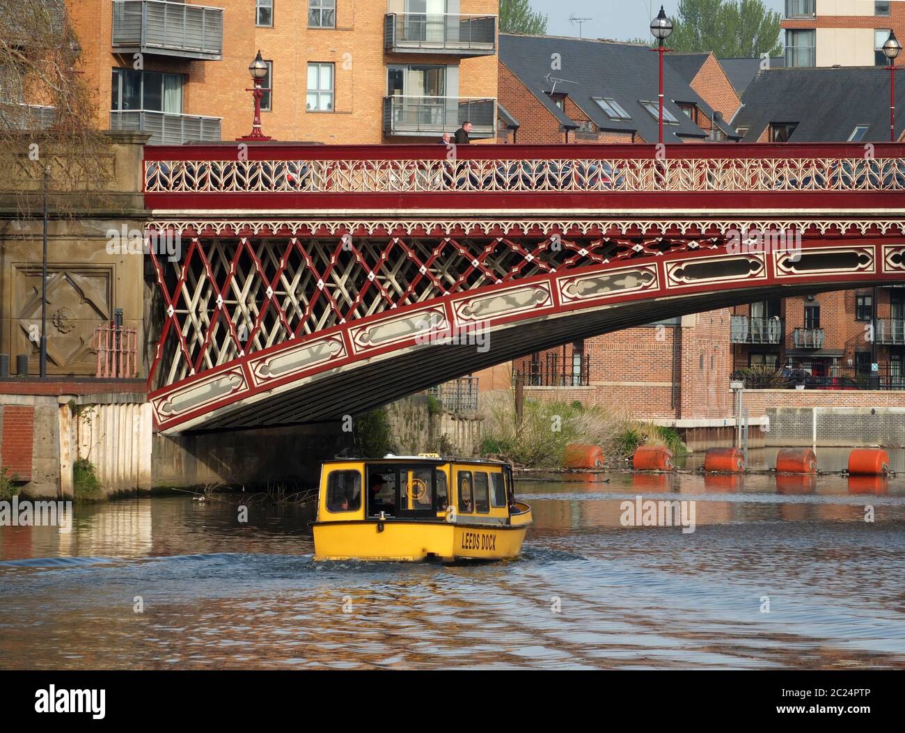 un taxi d'acqua giallo che passa sotto il ponte crown point sul fiume aire a leeds Foto Stock