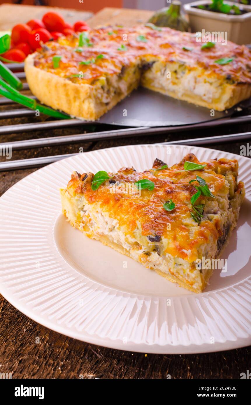 Il francese Quiche con melanzane, porri e cipollotti, immersa in una deliziosa panna e cotto al forno fino a quando non diventano croccanti Foto Stock