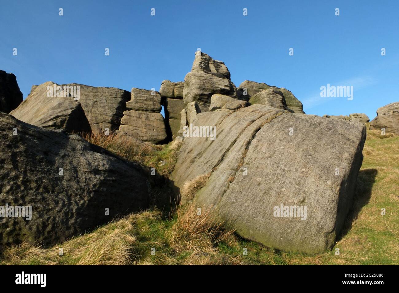 grande e robusto affioramento di pietra gritstone ai bridestones una grande formazione rocciosa nello yorkshire occidentale vicino a todmordenwith cielo blu e surro Foto Stock