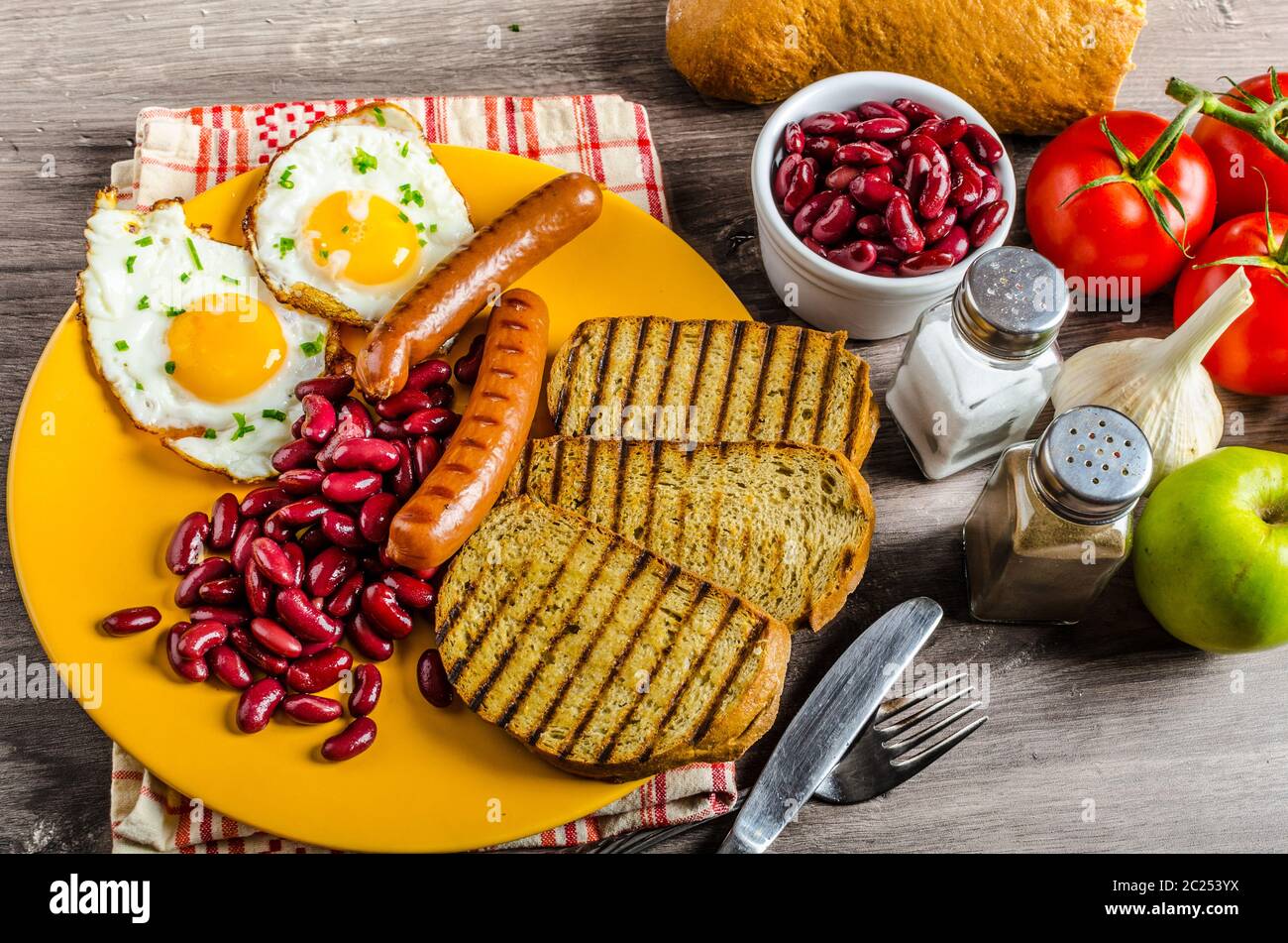 Prima colazione inglese - aglio toast, uova fritte, fagioli e salsicce salati Foto Stock