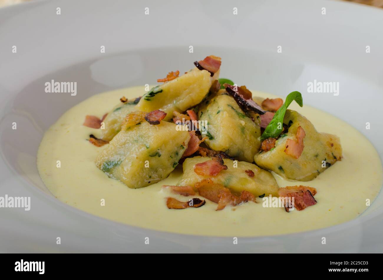 Gnocchetti di spinaci con salsa di Parmigiano e rabboccato con pancetta, pulire serve, ingredienti in background Foto Stock