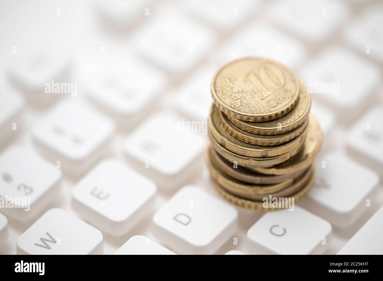 Monete metalliche in euro sulla tastiera del computer Foto Stock