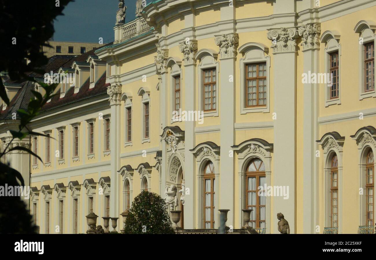 Facciata di un palazzo barocco in giallo e grigio chiaro con file di finestre Foto Stock