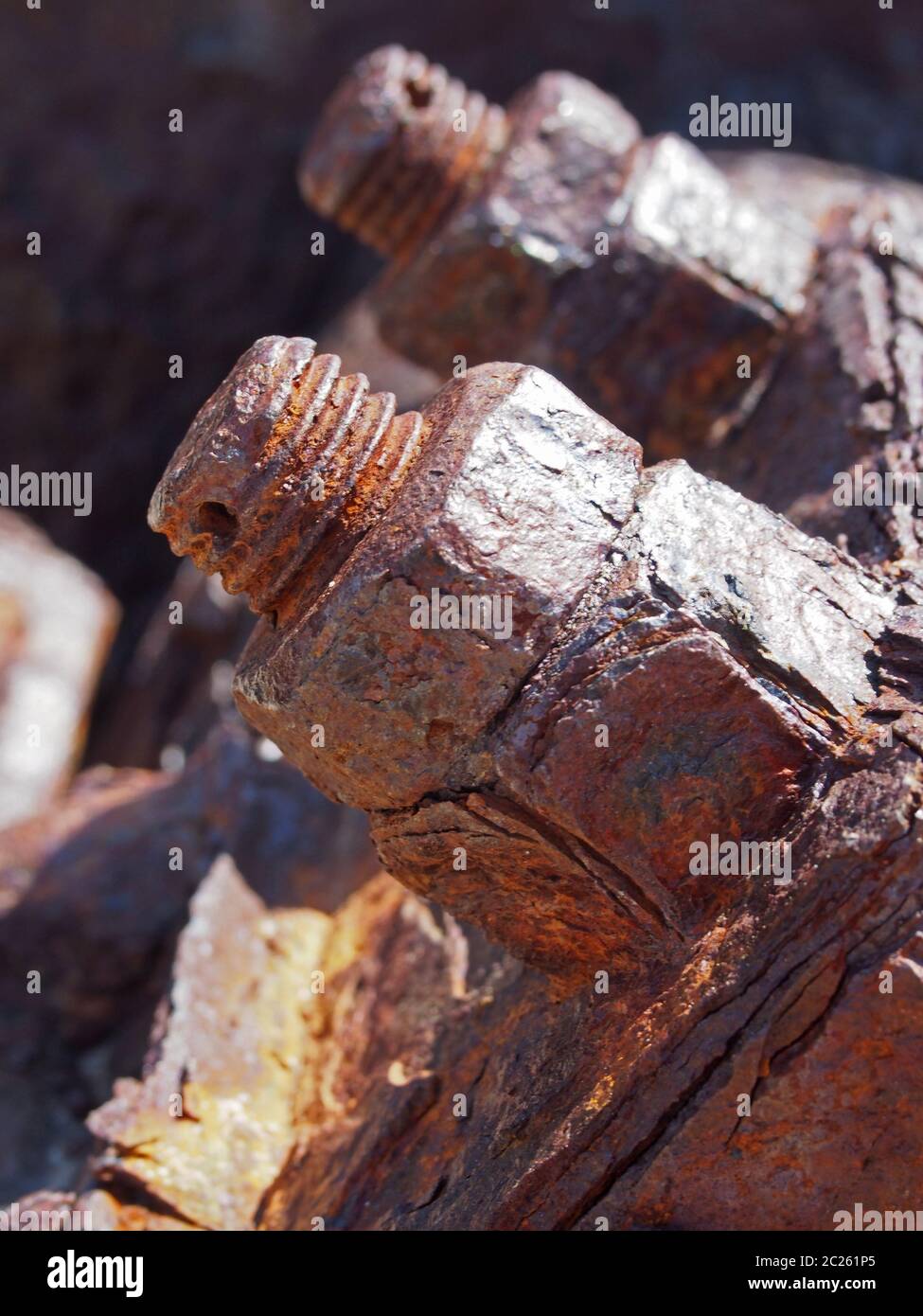 primo piano di bulloni e dadi filettati arrugginiti marroni su vecchi macchinari corrosi Foto Stock
