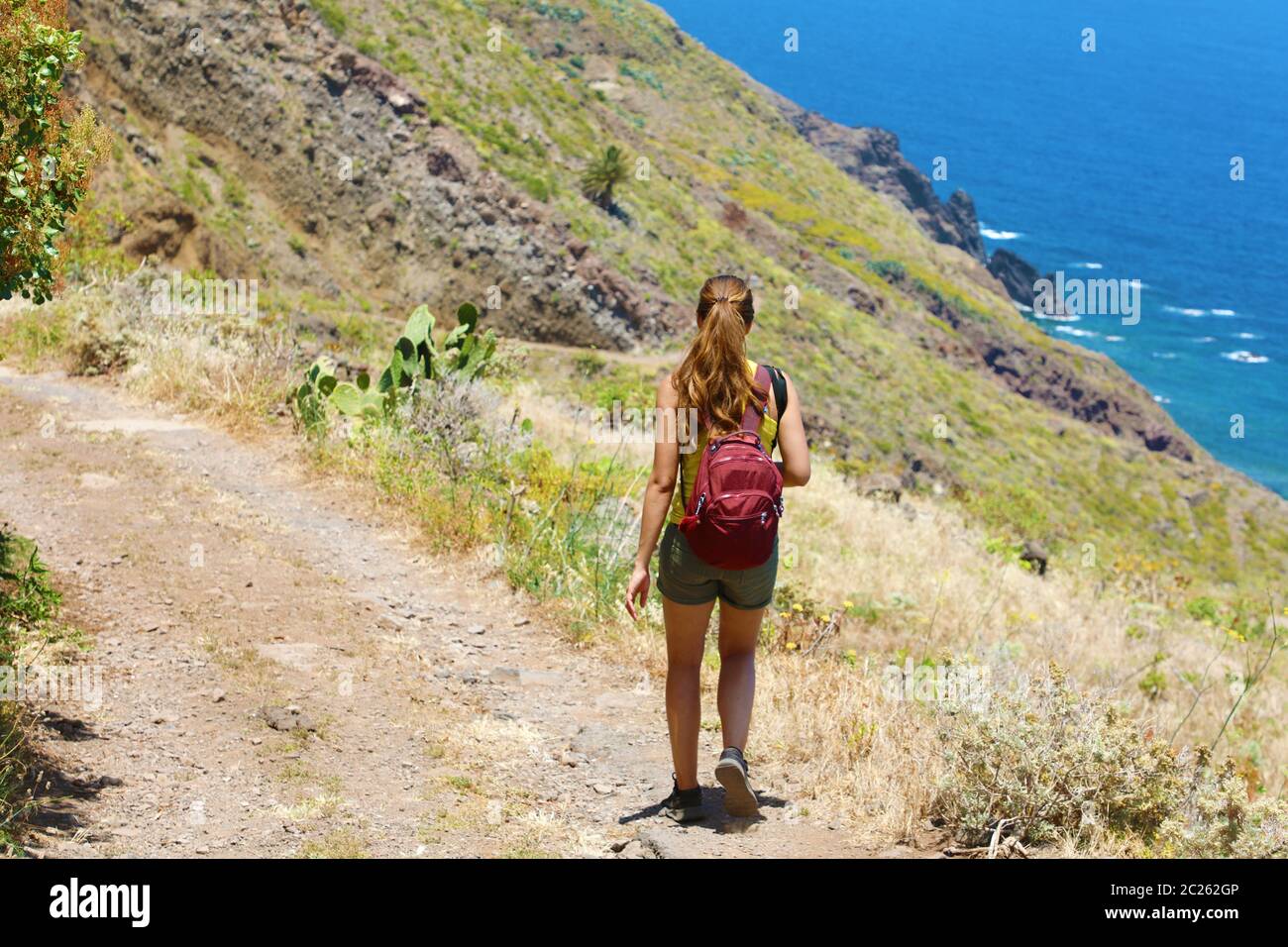 Traveler escursionista donna a piedi lungo il sentiero sulle montagne di Tenerife. Turismo naturale backpacker trekking adventure concept. Foto Stock