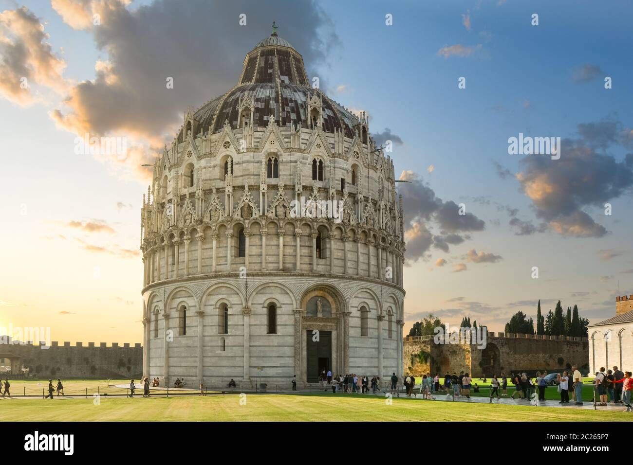 Lo storico Battistero rotondo accanto alla torre e al Duomo sul campo dei Miracoli, nella città toscana di Pisa al tramonto. Foto Stock