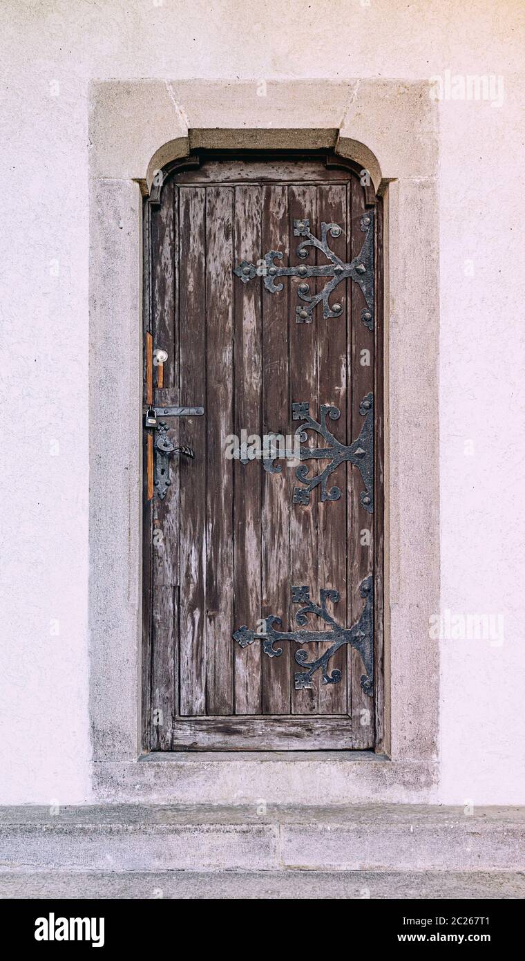 Chiusa antica porta in legno con cardini di ferro battuto Foto Stock