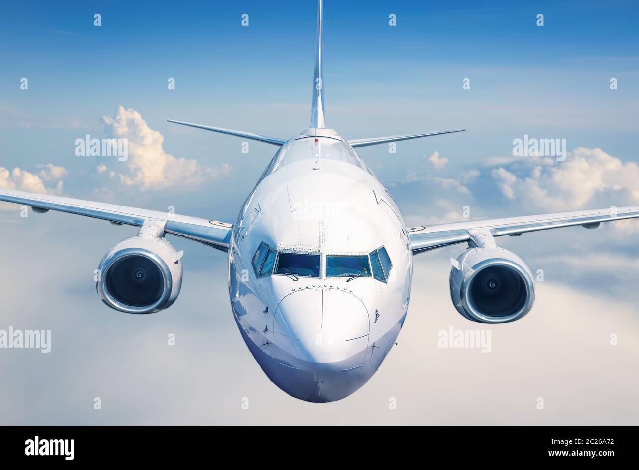 il moderno aereo di linea vola in un cielo blu tra le nuvole Foto Stock