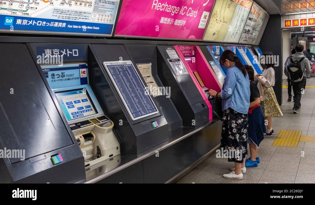Pendolari che acquistano il pass per i mezzi pubblici presso il distributore automatico di biglietti, Tokyo, Giappone Foto Stock