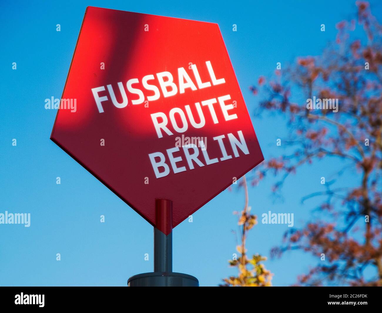 Segno pentagonale rosso con l'iscrizione SULLA ROTTA DI CALCIO BERLINO di fronte al cielo blu a Berlino-Frohnau. Queste indicazioni conducono a destra attraverso il footbal di Berlino Foto Stock