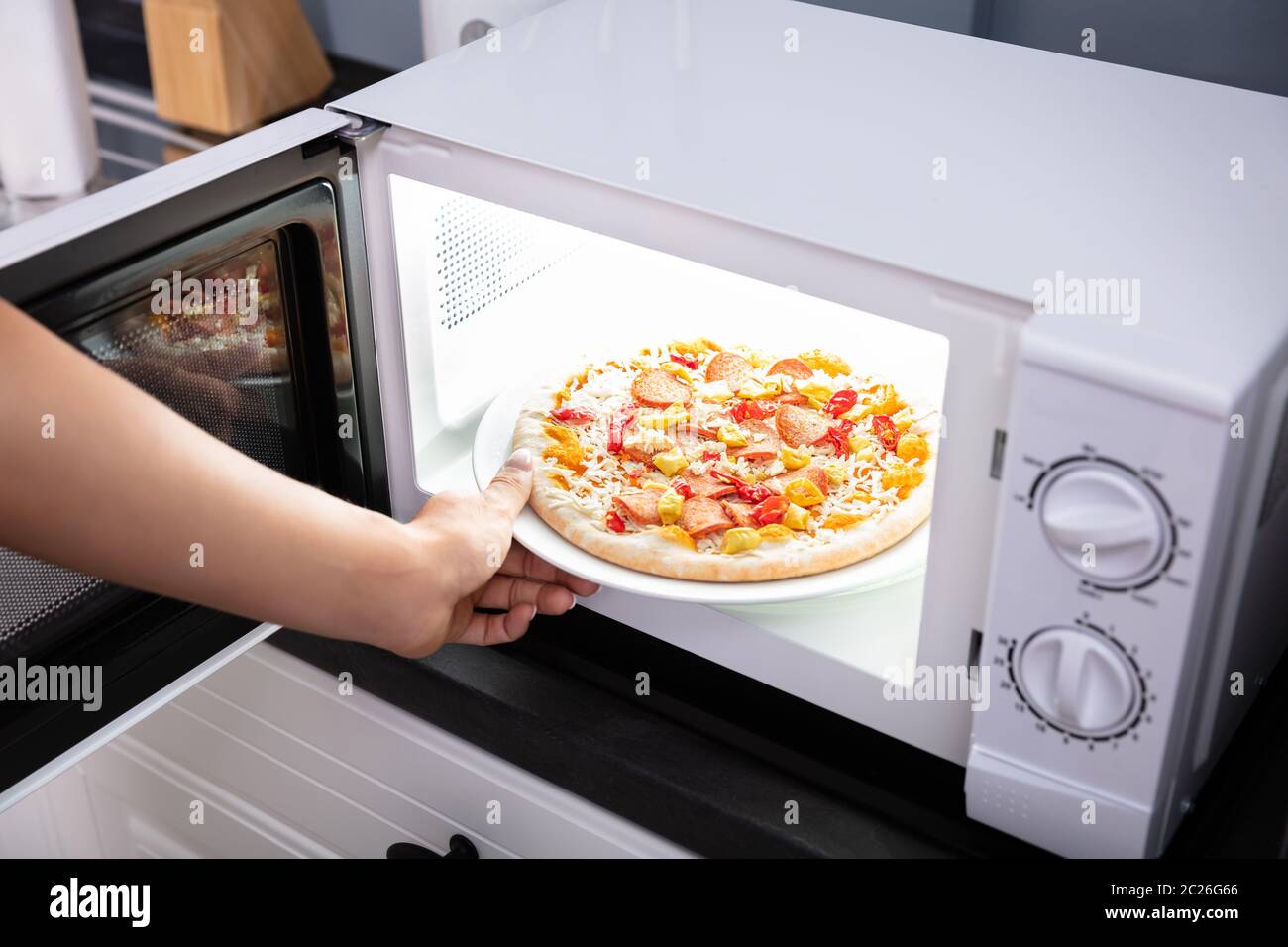 Close-up di una donna felice cuocere la pizza in forno a microonde Foto  stock - Alamy