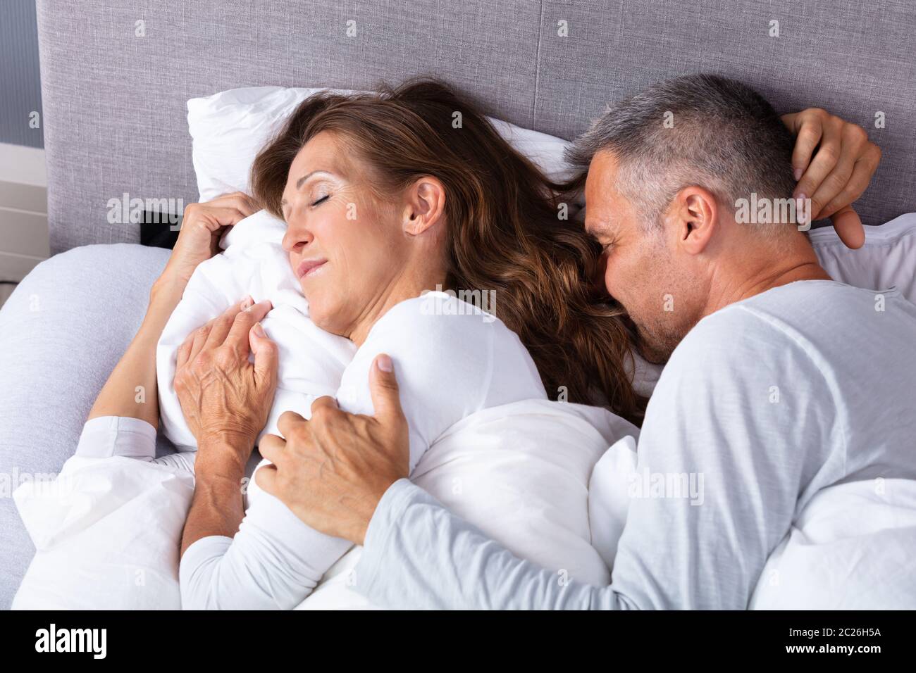 Coppia amare giovane che dorme sul letto con coltre bianca Foto Stock