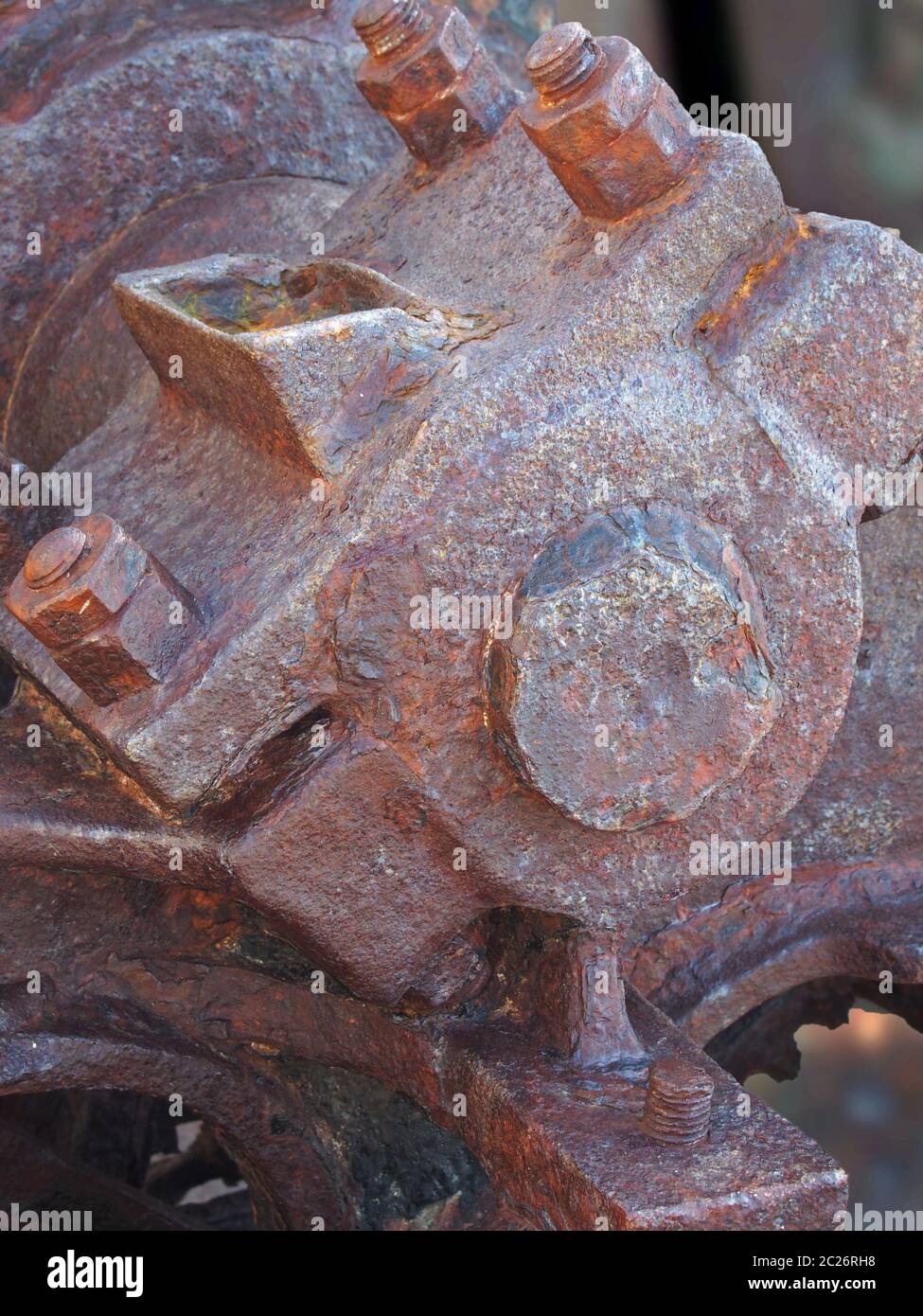 primo piano di bulloni assale e ruota su vecchi macchinari industriali arrugginiti abbandonati Foto Stock