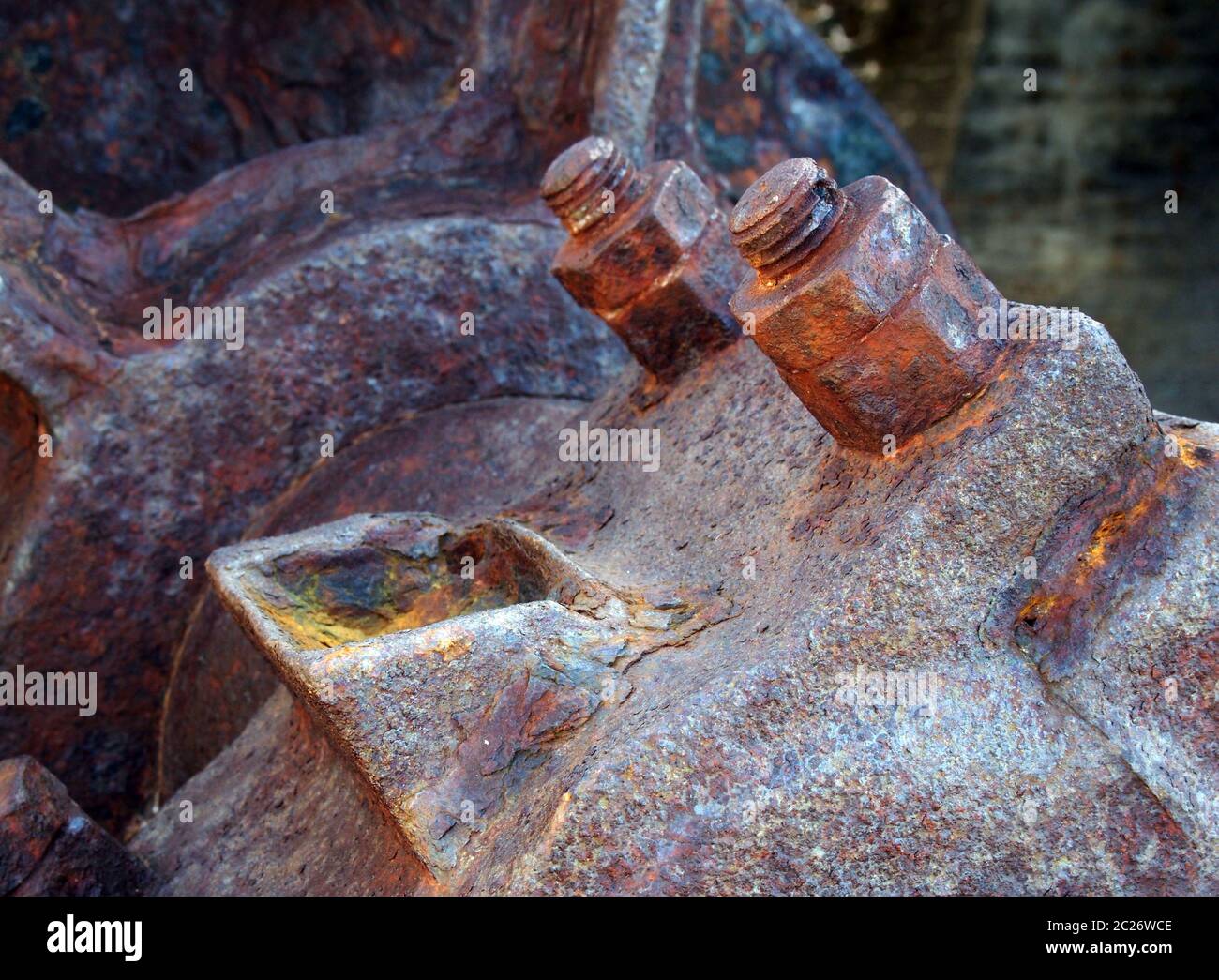 primo piano di bulloni assale e ruota su vecchi macchinari industriali arrugginiti abbandonati Foto Stock