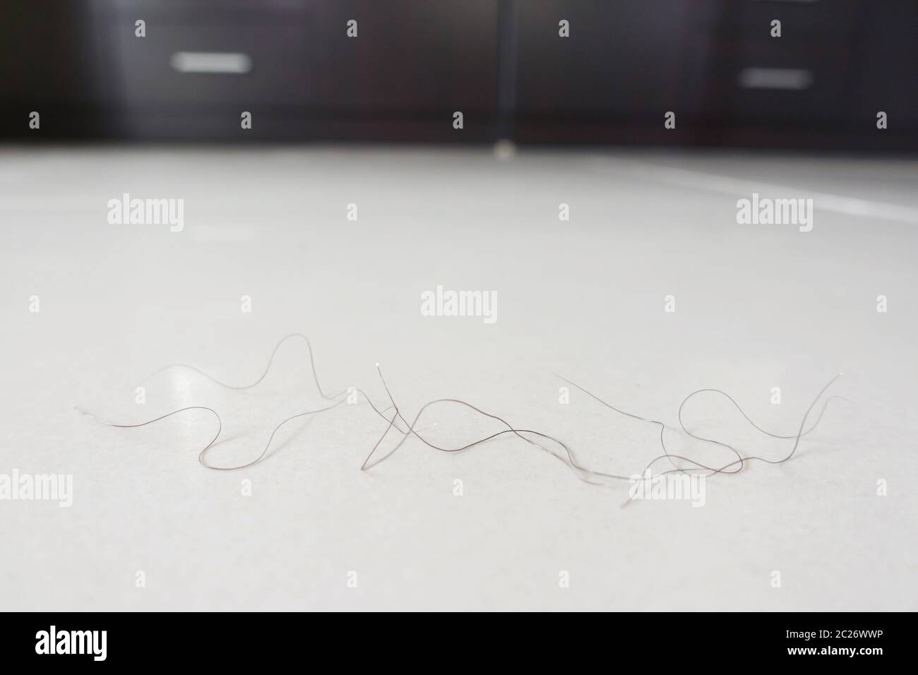 Capelli pubici cadere sul pavimento della camera Foto Stock