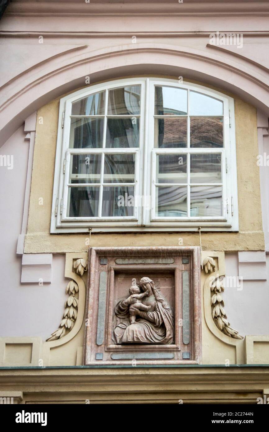 Una scultura in marmo di madre e bambino sulle pareti del palazzo di primati nella città antica di Bratislava, Slovacchia Foto Stock