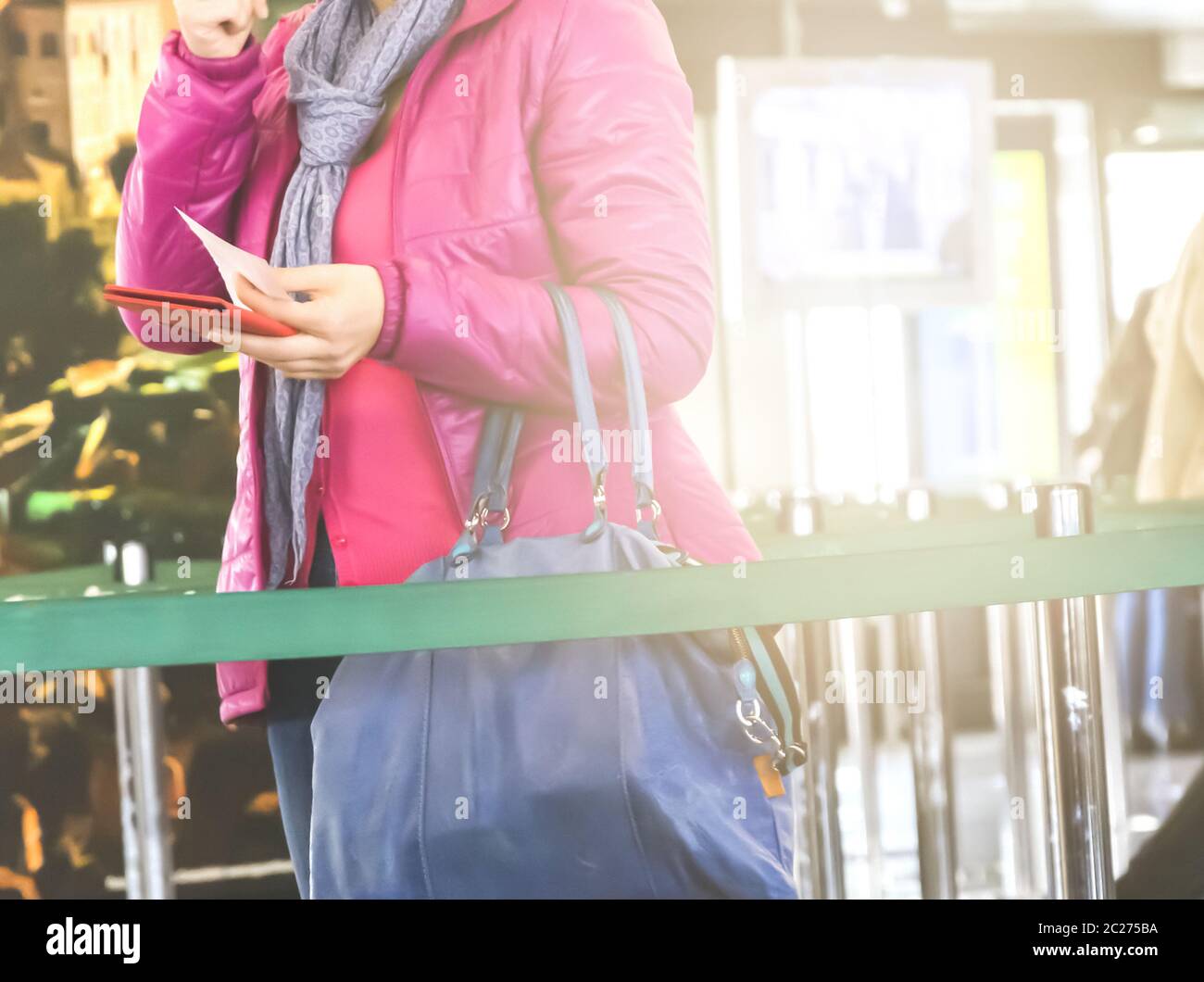 donna irriconoscibile tiene il passaporto in mano per i controlli di sicurezza in aeroporto Foto Stock