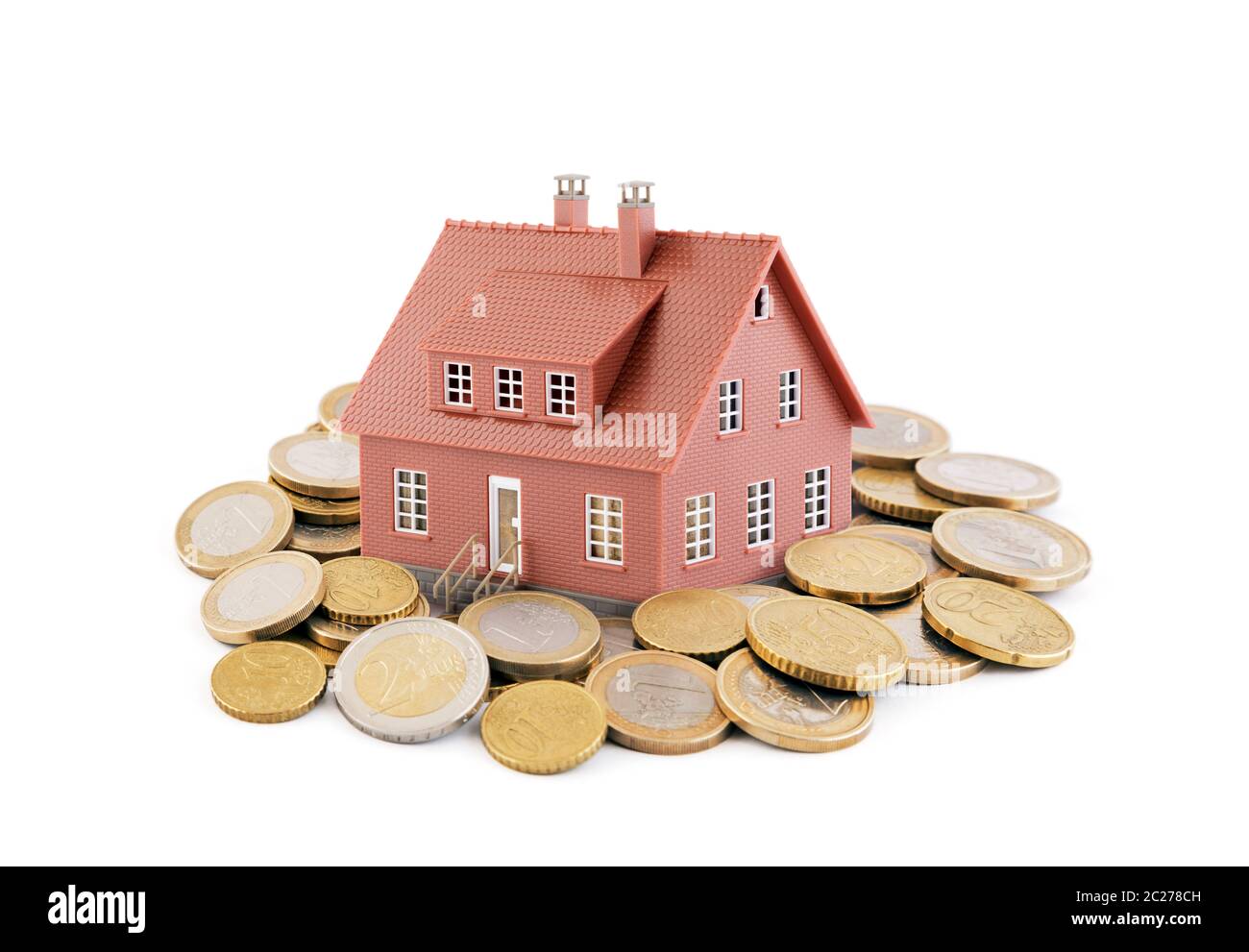 Piccolo marrone toy house con le monete in euro su sfondo bianco Foto Stock
