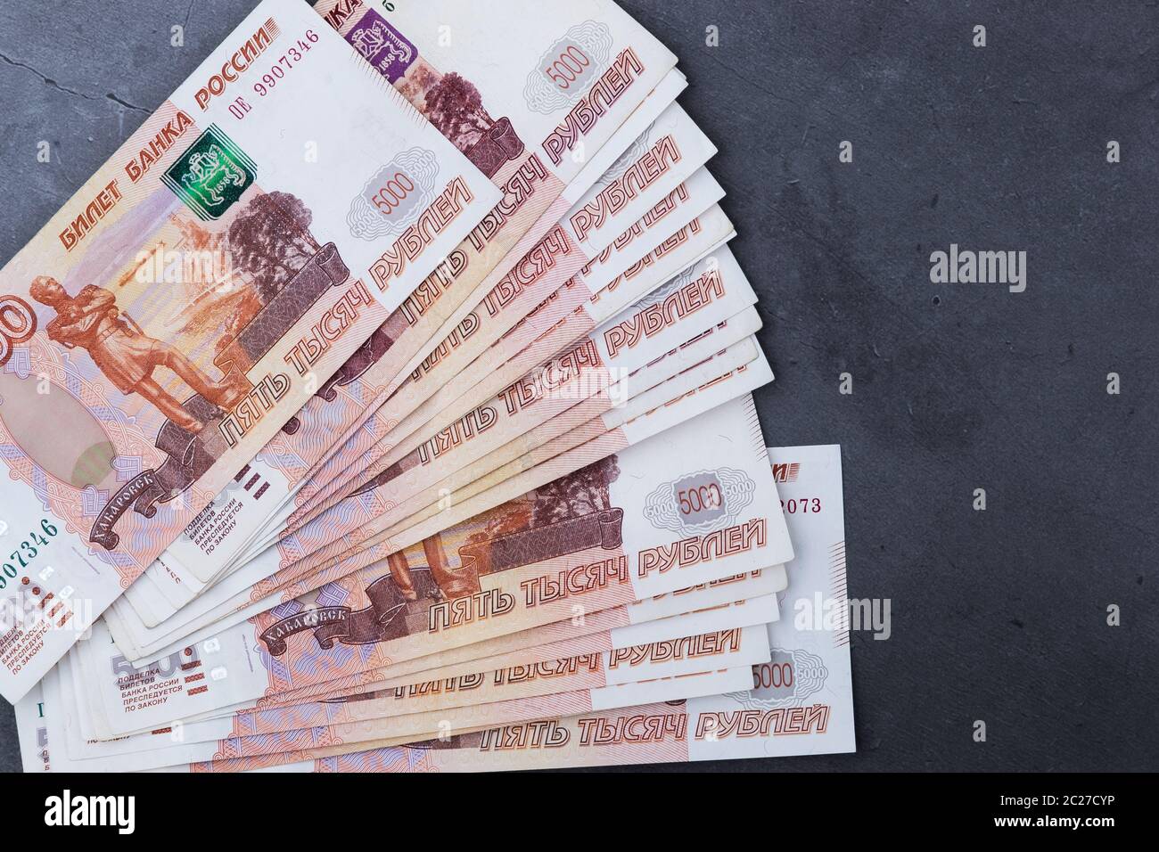 Grande pila di denaro russo banconote di cinque mila rubli giacente su un cemento grigio sfondo Foto Stock