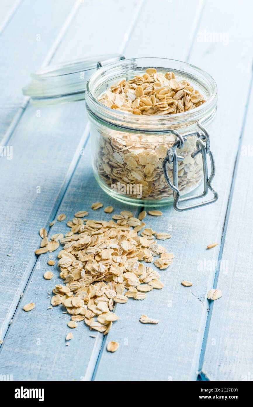 Heathy fiocchi di avena. Farina di avena sul tavolo blu. Foto Stock