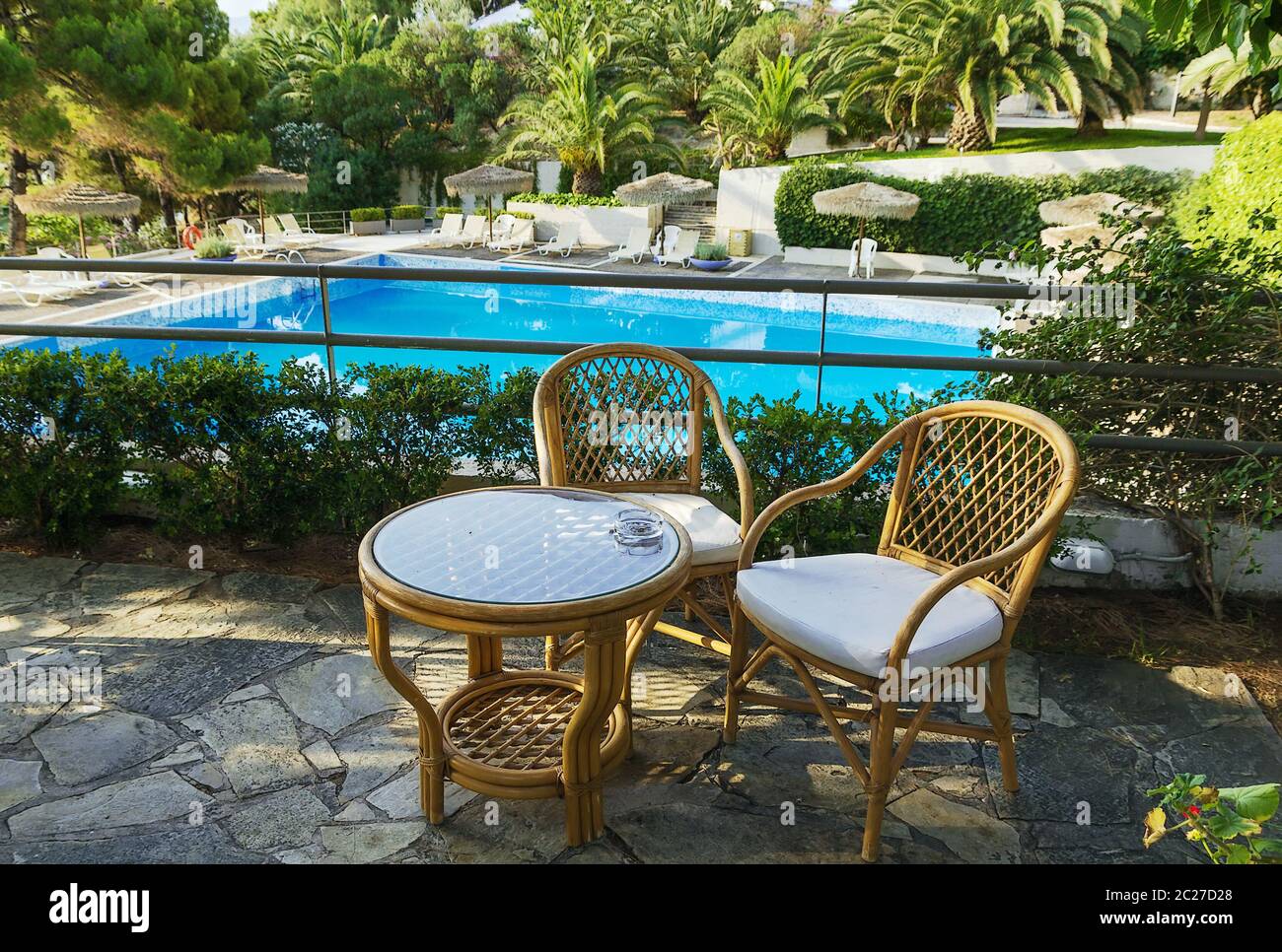 tavolo e sedie per il riposo che si affaccia sulla piscina Foto Stock