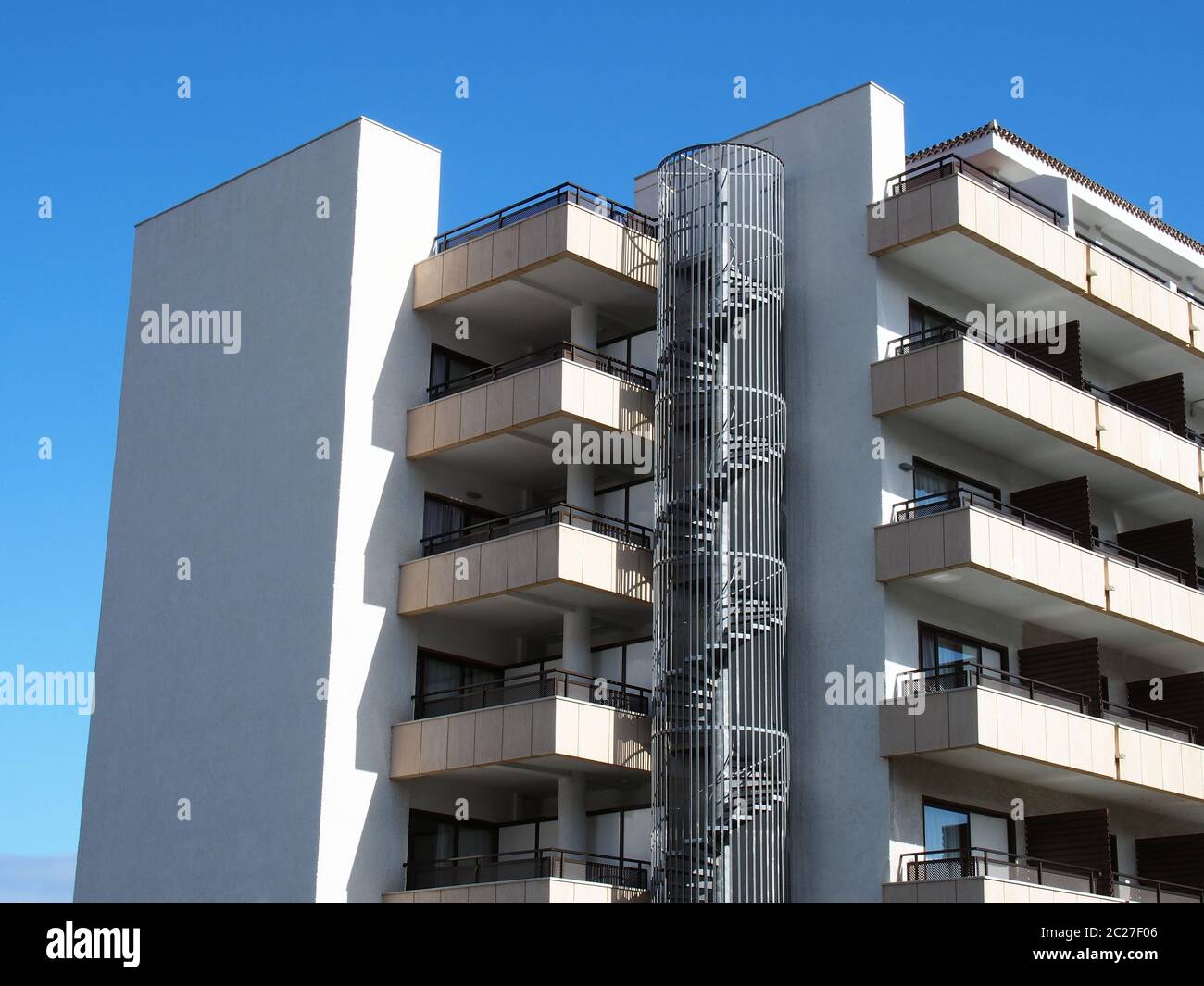 moderno complesso di appartamenti con caminetto circolare in metallo con scale a spirale e balconi eleganti ad angolo Foto Stock